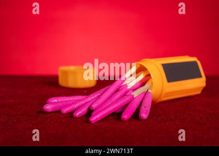 boîte de bâtons de match coupe-vent et imperméables sur fond rouge à composition horizontale Banque D'Images