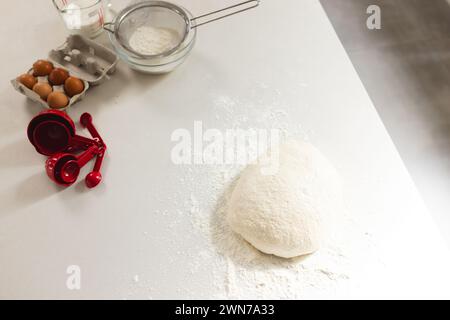 Scène de cuisson avec farine, pâte et ingrédients prêts sur le comptoir. Banque D'Images