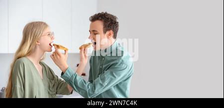 Jeune couple mangeant des toasts savoureux avec du beurre de noix dans la cuisine. Bannière pour la conception Banque D'Images