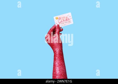 Main féminine peinte avec carte-cadeau sur fond de couleur, gros plan Banque D'Images