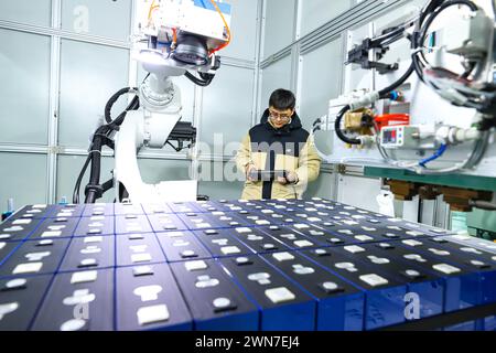 ZHANGYE, CHINE - 29 FÉVRIER 2024 - Un membre du personnel vérifie le fonctionnement sur un contrôleur d'ordinateur à une chaîne de production automatisée pour PACK, an Banque D'Images