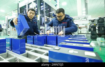 ZHANGYE, CHINE - 29 FÉVRIER 2024 - les travailleurs chargent des modules de stockage d'énergie dans la ligne de production d'une ligne de production automatisée pour l'énergie St Banque D'Images