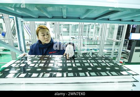 ZHANGYE, CHINE - 29 FÉVRIER 2024 - Un membre du personnel vérifie les accessoires d'une chaîne de production automatisée pour la fabrication d'équipements de stockage d'énergie Banque D'Images