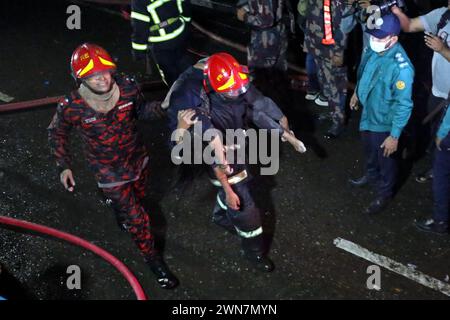 Dhaka, Wari, Bangladesh. 1er mars 2024. Contenu graphique/les pompiers transportent une personne blessée lors d’opérations de sauvetage suite à un incendie dans un bâtiment commercial qui a tué au moins 43 personnes à Dacca. Au moins 43 personnes ont été tuées et des douzaines blessées après un incendie qui a ravagé un bâtiment de sept étages dans un quartier chic de la capitale bangladaise, Dhaka, à la fin du mois de février 29, ont déclaré les autorités sanitaires. (Crédit image : © Habibur Rahman/ZUMA Press Wire) USAGE ÉDITORIAL SEULEMENT! Non destiné à UN USAGE commercial ! Banque D'Images