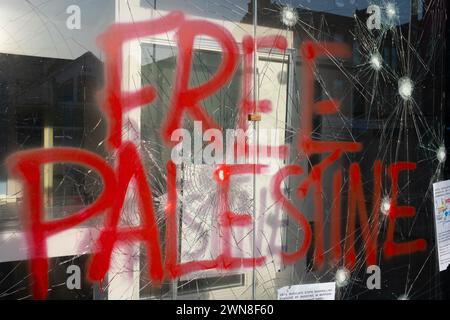 Glasgow, Royaume-Uni, 1er mars 2024. Fenêtres brisées et graffitis lisant « Barcleys Funds génocide » et « Free Palestine » sur la Barclays Bank dans le quartier Shawlands de Glasgow, en Écosse, le 1er mars 2024. Photo de Jeremy Sutton-Hibbert/Alamy Live News. Banque D'Images