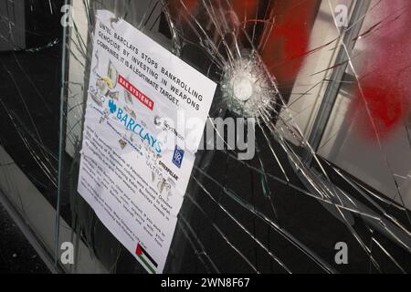 Glasgow, Royaume-Uni, 1er mars 2024. Fenêtres brisées et graffitis lisant « Barcleys Funds génocide » et « Free Palestine » sur la Barclays Bank dans le quartier Shawlands de Glasgow, en Écosse, le 1er mars 2024. Photo de Jeremy Sutton-Hibbert/Alamy Live News. Banque D'Images