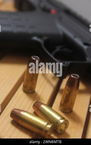 Un pistolet avec des balles sur une table en bois Banque D'Images