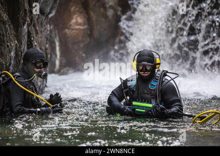 Une équipe de plongeurs utilise un équipement de détection de métaux pour trouver de l'or dans une rivière Banque D'Images