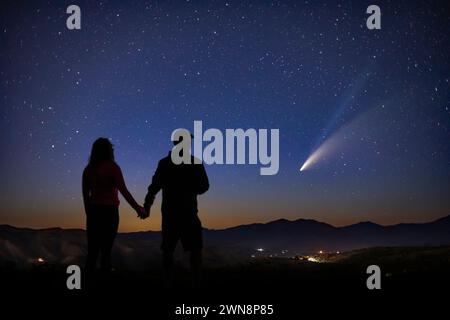 un homme et une femme se dressent dans la crainte tandis qu'ils regardent la magnifique comète Banque D'Images