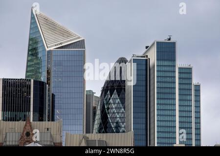 L'horizon de la ville de Londres avec l'emblématique bâtiment Gherkin encadré par les bâtiments modernes qui l'entourent. Le Gherkin, anciennement 30 St Mary axe et anciennement connu sous le nom de Swiss Re Building, est un gratte-ciel commercial situé dans le principal quartier financier de Londres, la City of London. Il a été achevé en décembre 2003 et ouvert en avril 2004.[10] avec 41 étages, il mesure 180 mètres (591 pieds) de haut[3] et se trouve sur les sites de l'ancienne Bourse Baltique et Chambre de la marine marchande. qui ont été fortement endommagés en 1992 lors du bombardement de la Baltic Exchange par un engin placé par l'IRA provisoire. Banque D'Images