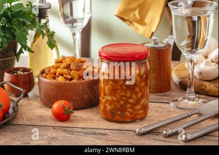 haricots marinés dans un bocal en verre et dans une assiette sur la table Banque D'Images