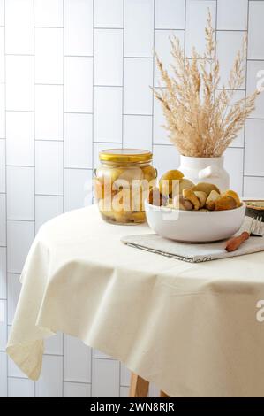 champignons marinés dans un bocal en verre et dans une assiette sur la table Banque D'Images