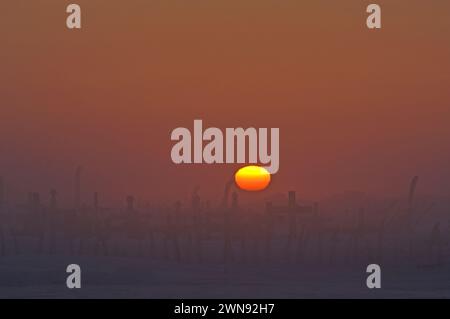 Coucher de soleil sur le site du cimetière marqué par des os de côtes de baleine à l'extérieur du plus ancien village Inupiat de point Hope Tigia Arctic Alaska Banque D'Images