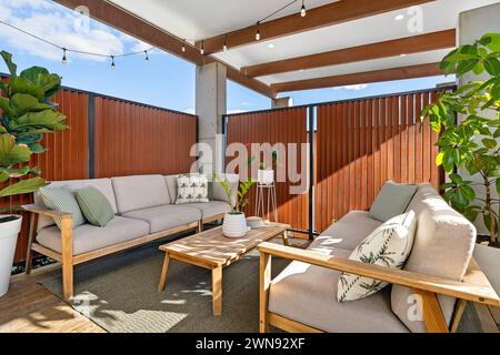 Un espace extérieur en plein air avec terrasse en bois, sièges et tables Banque D'Images