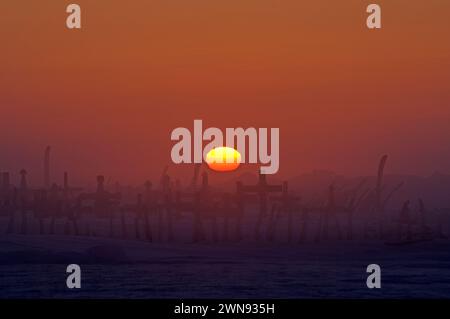 Coucher de soleil sur le site du cimetière marqué par des os de côtes de baleine à l'extérieur du plus ancien village Inupiat de point Hope Tigia Arctic Alaska Banque D'Images