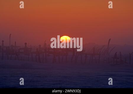 Coucher de soleil sur le site du cimetière marqué par des os de côtes de baleine à l'extérieur du plus ancien village Inupiat de point Hope Tigia Arctic Alaska Banque D'Images