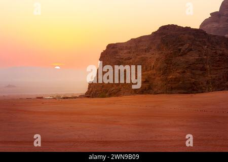 Jordanie, Wadi Rum soleil apparaît au-dessus de l'horizon, lever du soleil dans le désert, tentes de camp Banque D'Images