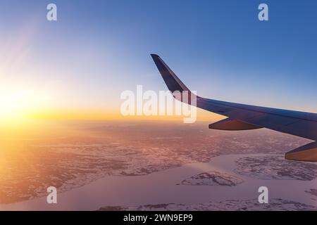Avion volant bas au-dessus de montagnes enneigées et se préparant à atterrir à l'aéroport, vue depuis la fenêtre de l'avion de la turbine d'aile et de l'horizon Banque D'Images