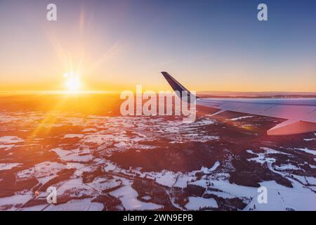 Avion volant bas au-dessus de montagnes enneigées et se préparant à atterrir à l'aéroport, vue depuis la fenêtre de l'avion de la turbine d'aile et de l'horizon Banque D'Images