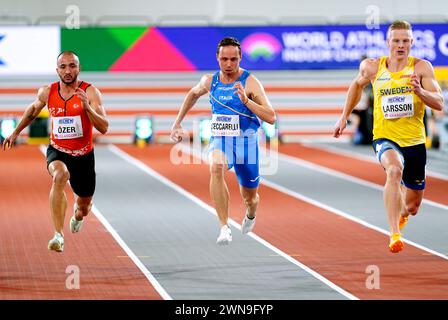 Le turc Kayhan Ozer, l'italien Samuele Ceccarelli et le suédois Henrik Larsson en action alors qu'ils participent à la Heat 2 du 60 mètres masculin lors de la première journée des Championnats du monde d'athlétisme en salle à l'Emirates Arena de Glasgow. Date de la photo : vendredi 1er mars 2024. Banque D'Images