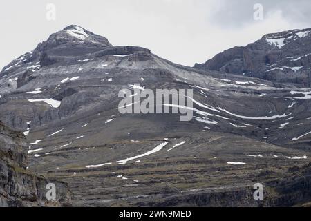 paysage montagneux accidenté avec des taches de neige sous un ciel nuageux Banque D'Images