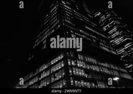 Puissant paysage architectural abstrait monochrome de bureaux en gratte-ciel illuminés la nuit sur Bishopsgate près de Liverpool Street dans la City de Londres. Banque D'Images