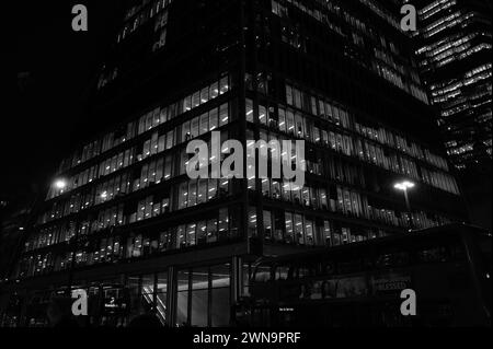 Puissant paysage architectural abstrait monochrome de bureaux en gratte-ciel illuminés la nuit sur Bishopsgate près de Liverpool Street dans la City de Londres. Banque D'Images