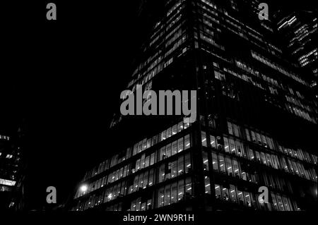 Puissant paysage architectural abstrait monochrome de bureaux en gratte-ciel illuminés la nuit sur Bishopsgate près de Liverpool Street dans la City de Londres. Banque D'Images