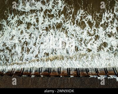 Les vagues de marée haute s'écrasent sur les revêtements à Overstrand, Norfolk, Royaume-Uni Banque D'Images