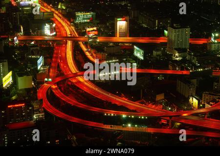 Bangkok autoroute et vue aérienne de l'autoroute la nuit dans la capitale de la Thaïlande. Rues sinueuses infrastructure de la ville d'en haut, paysage urbain avec g rouge Banque D'Images