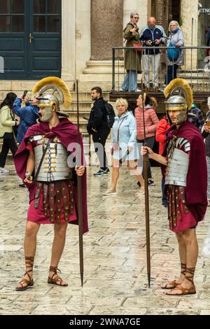 Acteurs en uniforme de soldats romains posant avec des touristes pour des photographies, palais de Dioclétien, Split, Croatie Banque D'Images