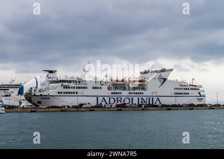 Grand ferry Jadrolinija amarré sous un ciel nuageux, avec d'autres navires en arrière-plan, Split, Croatie Banque D'Images