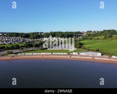Photographie aérienne par drone de la plage de sable de Goodrington près de Paignton Devon. Une plage de sable bleu calme avec une longue rangée de cabanes de plage et un ciel bleu clair Banque D'Images