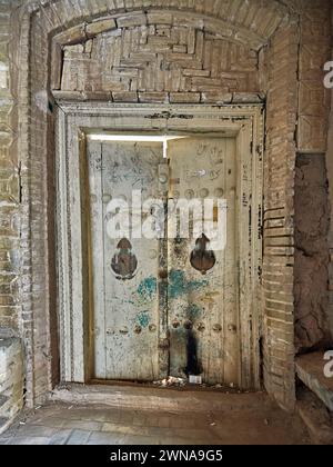 Porte en bois fermée d'un bâtiment abandonné dans la vieille ville de Yazd, Iran. Banque D'Images