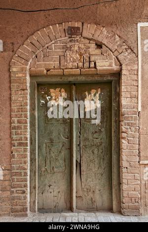 Porte en bois fermée d'une maison dans la vieille ville de Yazd, Iran. Banque D'Images