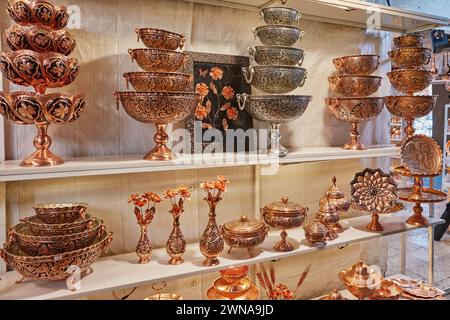 Une sélection de divers articles en cuivre faits à la main exposés dans une boutique de cadeaux à Yazd Coppersmiths Bazaar. Yazd, Iran. Banque D'Images