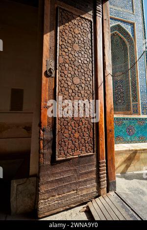 Vieille porte en bois massive avec sculpture élaborée dans la mosquée Jameh de Yazd, mosquée chiite de style azéri du XIVe siècle dans la vieille ville de Yazd, Iran. Banque D'Images