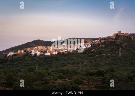 Paysage de la ville historique de Villafames entouré d'arbres au coucher du soleil avec le château sur le sommet de la colline, Castellon, Espagne Banque D'Images