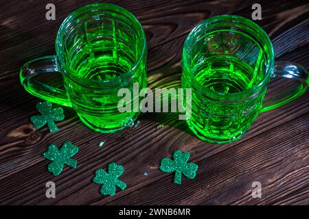 Deux verres de bière irlandaise verte, évoquant l'atmosphère animée de la fête dans un cadre de pub traditionnel. Prog Concept de la fête de Patrick Banque D'Images