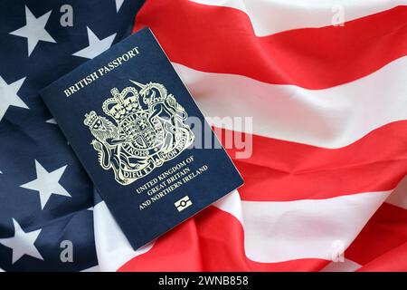 Passeport britannique bleu sur fond de drapeau national des États-Unis gros plan. Tourisme et concept de diplomatie Banque D'Images