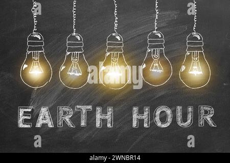 Ampoules avec lettrage EARTH HOUR main dessinées à la craie sur un tableau noir d'école. Sauvez le monde. Sauvez notre planète. Banque D'Images