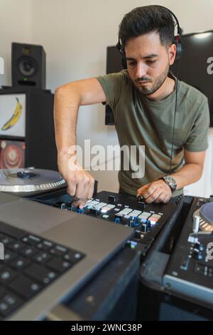 DJ ayant un bon moment tout en appuyant sur les boutons de la console pour créer de la musique. Banque D'Images