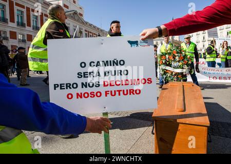 Madrid, Espagne. 01 mars 2024. Les éleveurs tiennent une banderole qui dit en galicien «la route sera difficile mais nous décidons de nos esprits ou de notre avenir», à côté d'eux un cercueil est vu lors d'une manifestation sur la place Puerta del sol. Un groupe d'éleveurs galiciens s'est réuni dans la matinée dans le centre de Madrid avec un cercueil et des couronnes funéraires pour représenter la 'mort de la campagne galicienne' (photo de David Canales/SOPA images/Sipa USA) crédit : Sipa USA/Alamy Live News Banque D'Images