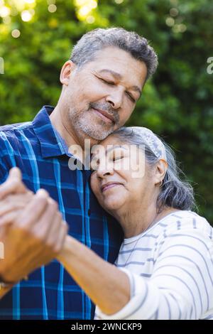 Couple biracial senior partage un moment tendre, avec le bras de l'homme autour de la femme Banque D'Images