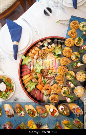 Un somptueux buffet présentant un assortiment somptueux de fruits de mer frais, sushis, salades, fruits et pâtisseries, magnifiquement disposé sur une table blanche immaculée Banque D'Images