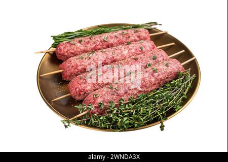 Brochettes de viande hachée crue kebabs dans une assiette avec des herbes. Isolé sur fond blanc. Vue de dessus Banque D'Images