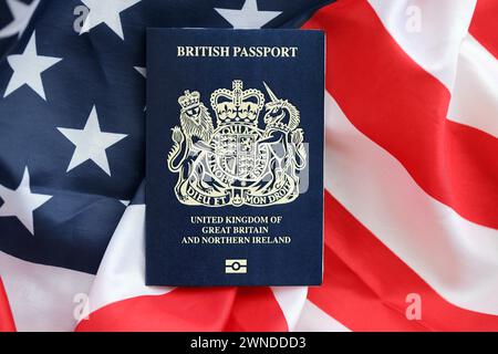 Passeport britannique bleu sur fond de drapeau national des États-Unis gros plan. Tourisme et concept de diplomatie Banque D'Images