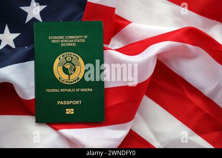 Passeport nigérian vert sur fond de drapeau national des États-Unis gros plan. Tourisme et concept de diplomatie Banque D'Images