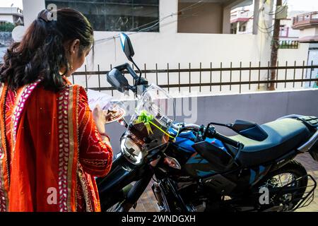 11 janvier 2024, Uttarakhand Inde. Jeune femme exécutant Pooja et rituels traditionnels sur un véhicule neuf pendant le Festival de Dhanteras, Banque D'Images