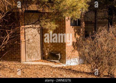 Vieilles toilettes publiques en briques rouges délabrées dans le parc forestier le jour ensoleillé en Corée du Sud Banque D'Images